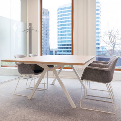 Een vergadertafel met stoelen voor een groot raam, perfect voor samenwerking en flexibele werkruimtes.