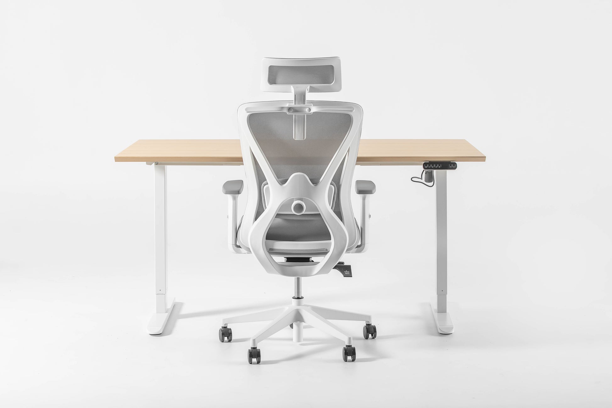 Een witte bureaustoel naast een houten bureau, perfect voor een zit-sta werkplek.